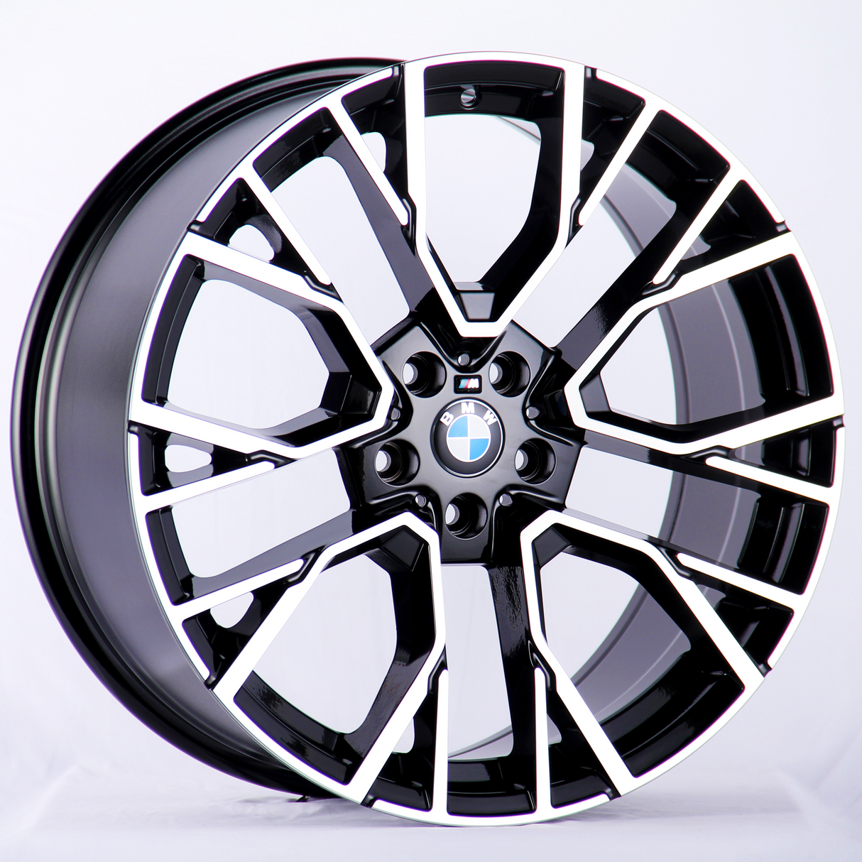 A BMW car wheel rim is displayed against a plain white background, featuring a modern, intricate black and silver geometric design with the BMW logo at the center.