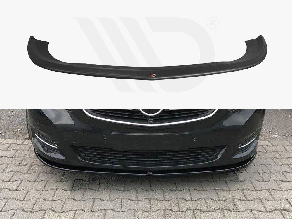 A black car front lip spoiler is shown both separately and installed on a dark-colored car, enhancing its aerodynamics. The car is parked on a stone-paved area.