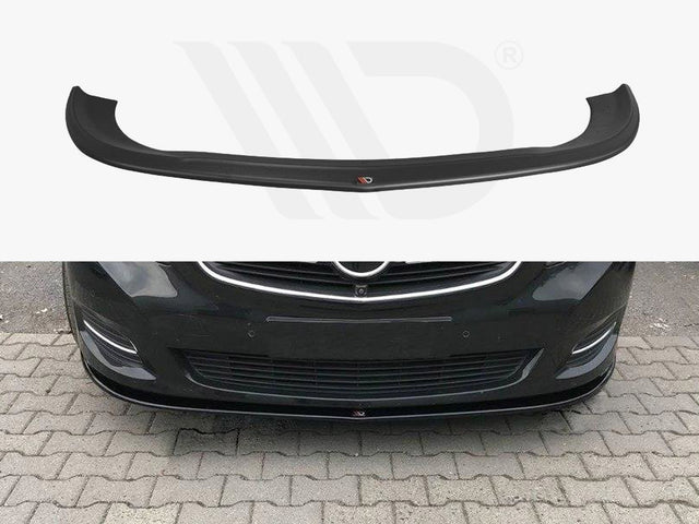 A black car front lip spoiler is shown both separately and installed on a dark-colored car, enhancing its aerodynamics. The car is parked on a stone-paved area.