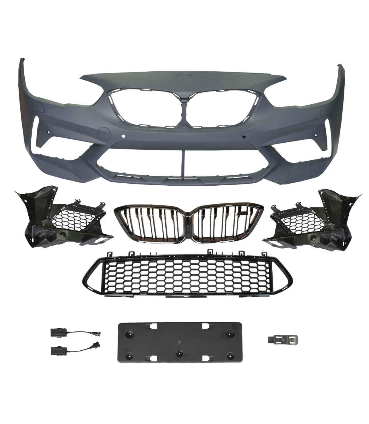 A collection of automotive parts includes a bumper cover, radiator grilles, and mounting brackets arranged on a plain background, suggesting components for vehicle front-end assembly.