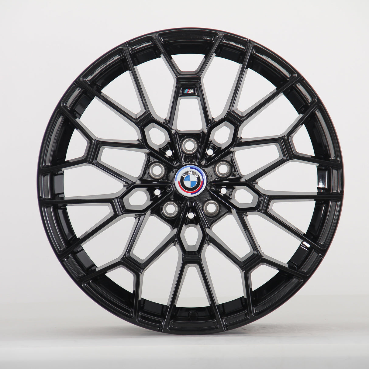 A glossy black, intricately designed car wheel with a central BMW logo and "M" insignia, set against a plain white background.