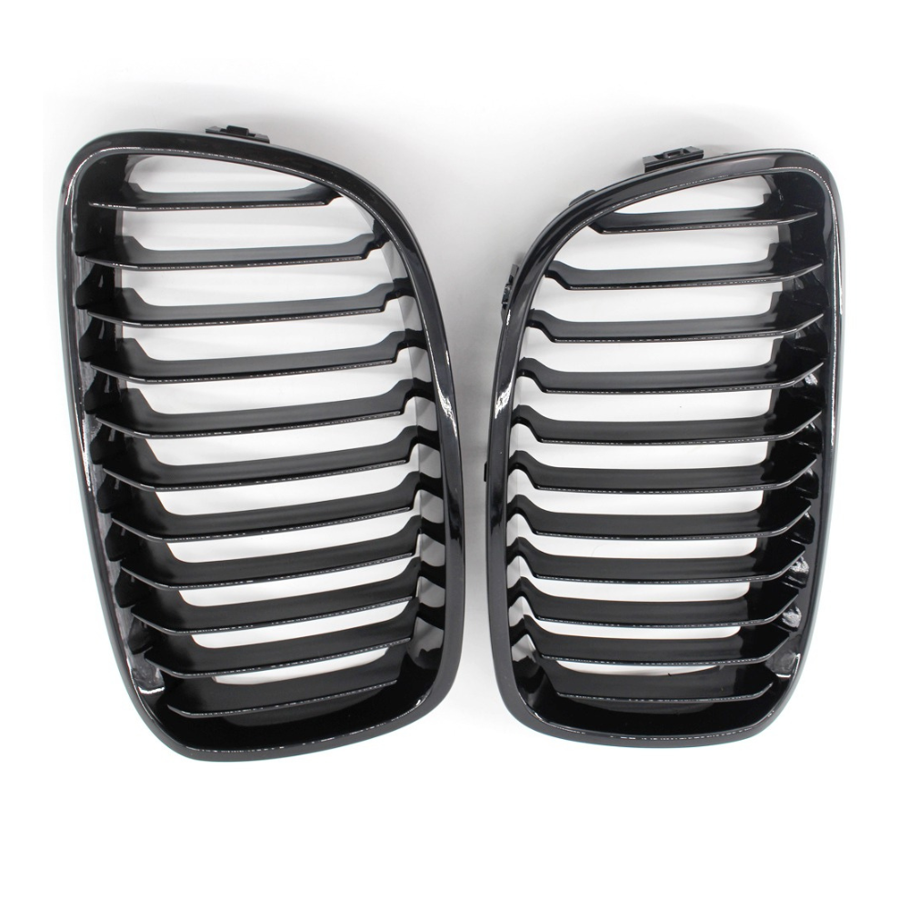 Two glossy black car grilles with horizontal slats are placed side by side against a plain white background.