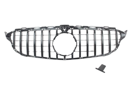 A car grille with vertical slats, designed for a front bumper, includes a circular central opening, placed on a plain white background. A small, detached piece lies nearby.