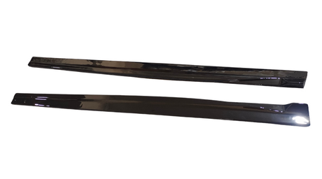 Two long, black plastic strips are placed parallel on a white background, reflecting light. They appear smooth and shiny, with slightly curved edges.