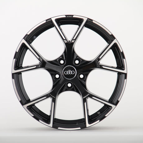 A sleek black alloy wheel with a glossy finish and five split spokes, featuring the Audi logo in the center, displayed against a plain white background.
