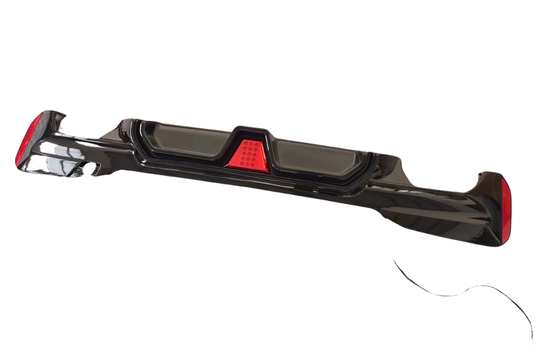 A glossy black car bumper with red reflector lights is displayed against a plain white background.