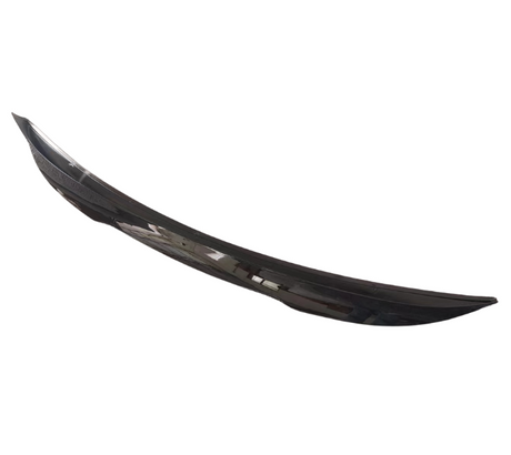A sleek, black car spoiler rests against a plain white background, showcasing its curved design and glossy finish.