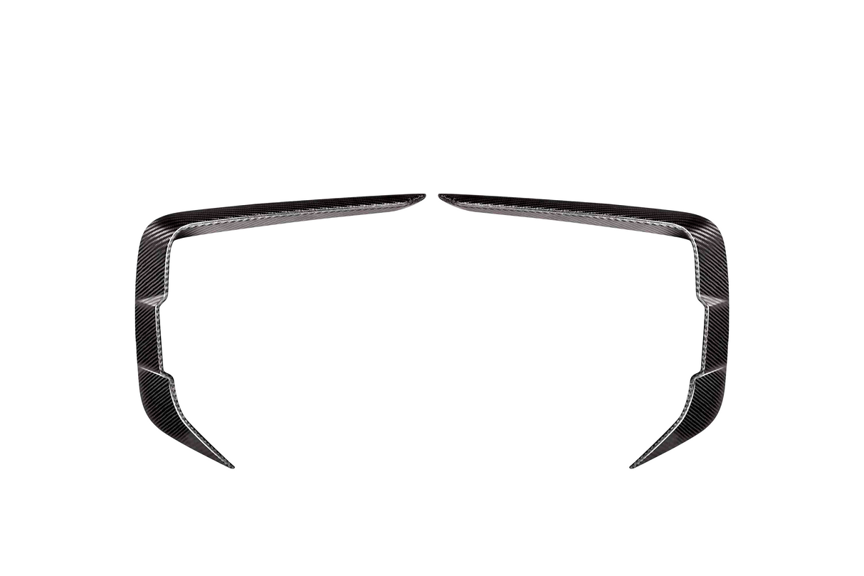 Two symmetrical, angled carbon fiber trim pieces facing each other on a plain white background, resembling elongated, curved brackets or stylized boomerangs.