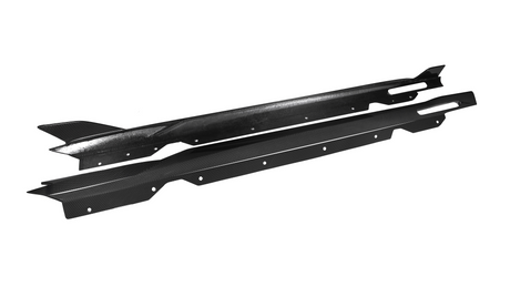 Two black carbon fiber car side skirts lie parallel, featuring aerodynamic fins and multiple mounting holes, against a plain white background.