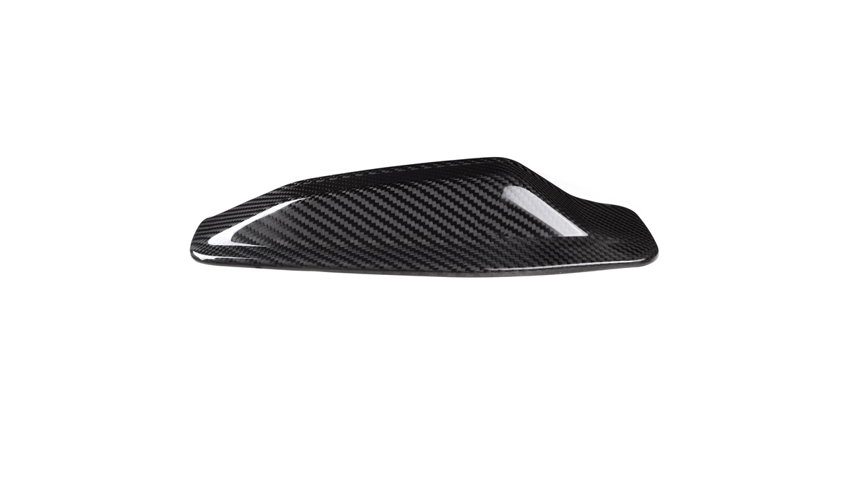 A sleek, black carbon fiber car mirror cap rests on a white background, showcasing its shiny, textured surface designed for aerodynamic enhancement.