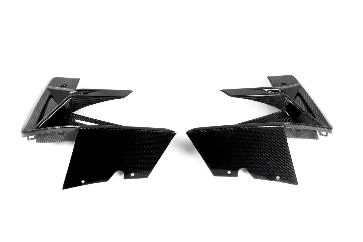 Two black carbon fiber car parts face each other, showcasing sleek, angular designs on a plain white background.