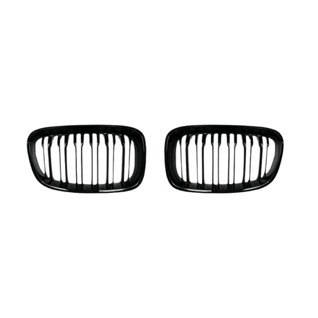 Two black, oval-shaped car grilles with vertical slats sit side by side against a plain white background, suggesting automotive components for vehicle front ends.