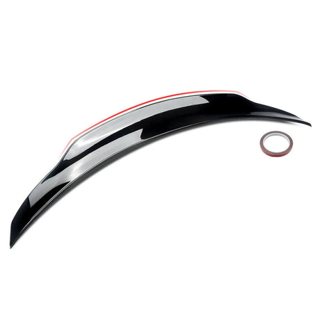 A glossy black car spoiler sits on a white background, accompanied by a small roll of adhesive tape, emphasizing its installation purpose.