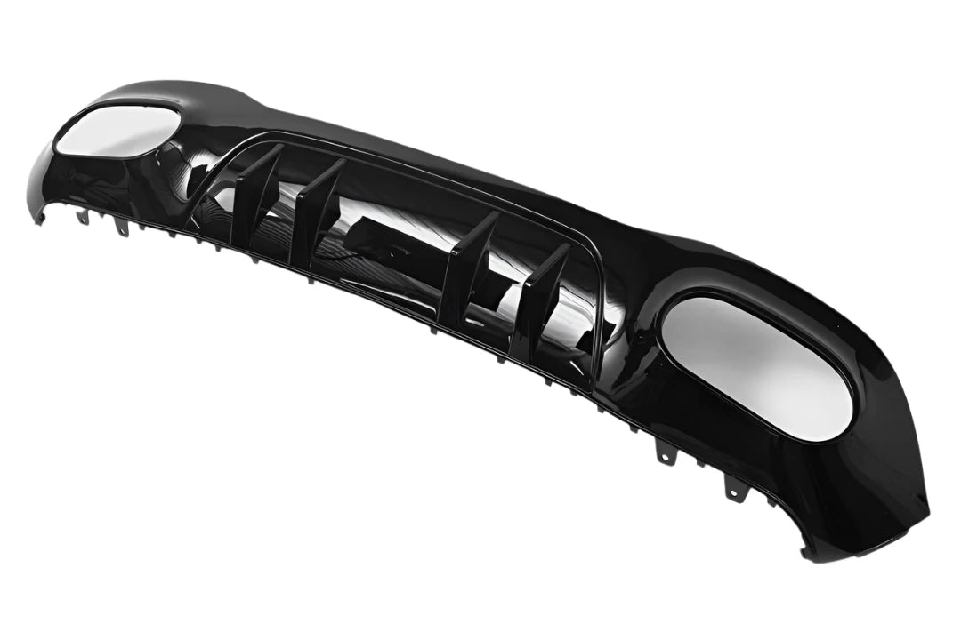 A glossy black car bumper with angular fins and aerodynamic design, lying on a plain white background.
