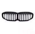 A glossy black car grille, featuring vertical slats, lies on a plain white background, designed to fit the front of a vehicle, enhancing its appearance and functionality.