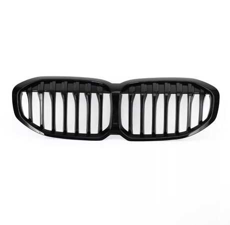A glossy black car grille, featuring vertical slats, lies on a plain white background, designed to fit the front of a vehicle, enhancing its appearance and functionality.