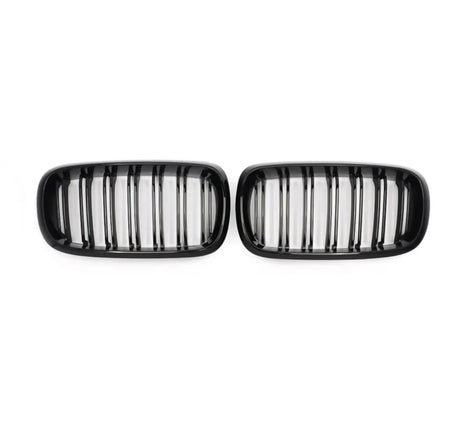 Two black kidney-shaped car grilles with vertical slats, positioned side by side on a plain white background.