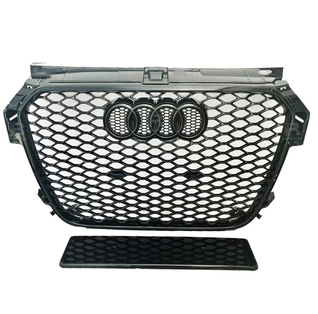 A black car grille with a honeycomb pattern featuring four interlinked rings at the center. It is positioned against a plain white background.