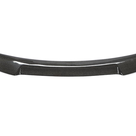 Carbon fiber car spoiler resting on a plain white background, showcasing its sleek, curved design and glossy texture, highlighting the material’s distinctive woven pattern.