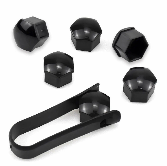 Black lug nut covers and a removal tool are arranged on a plain background. The covers are hexagonal, reflecting light, while the tool is elongated with gripping ends for ease of use.