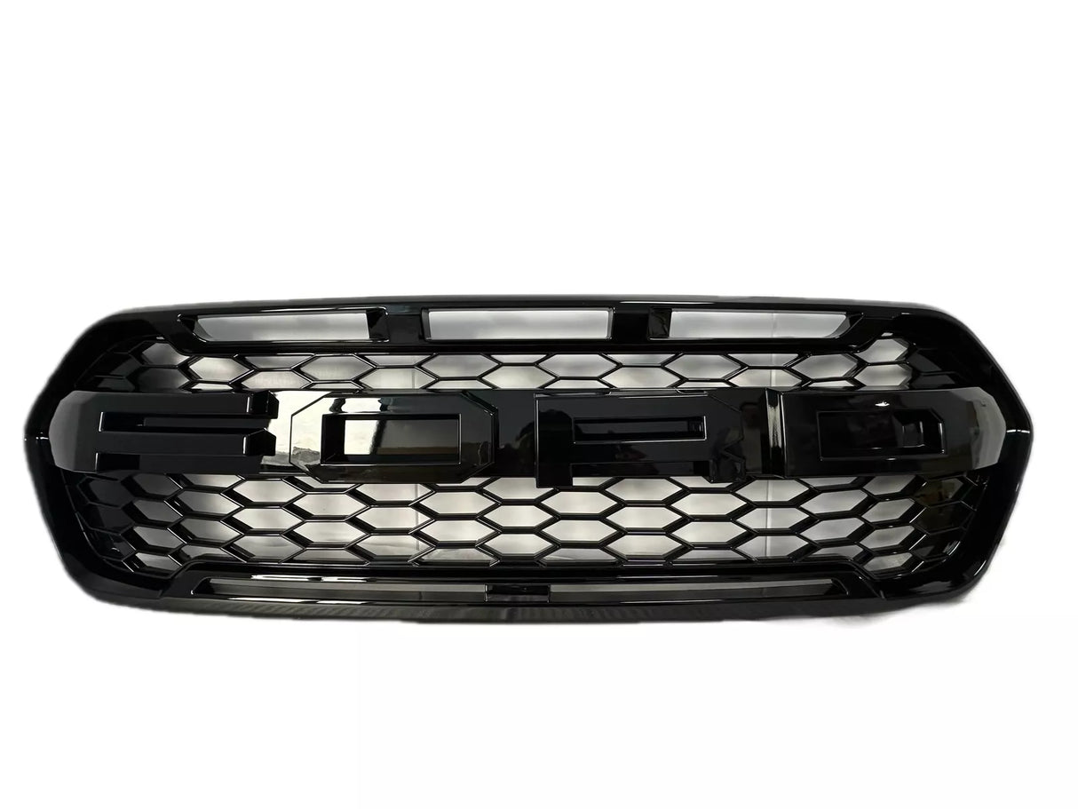A black car grille featuring large, bold "FORD" lettering, designed with a honeycomb pattern, set against a plain white background.