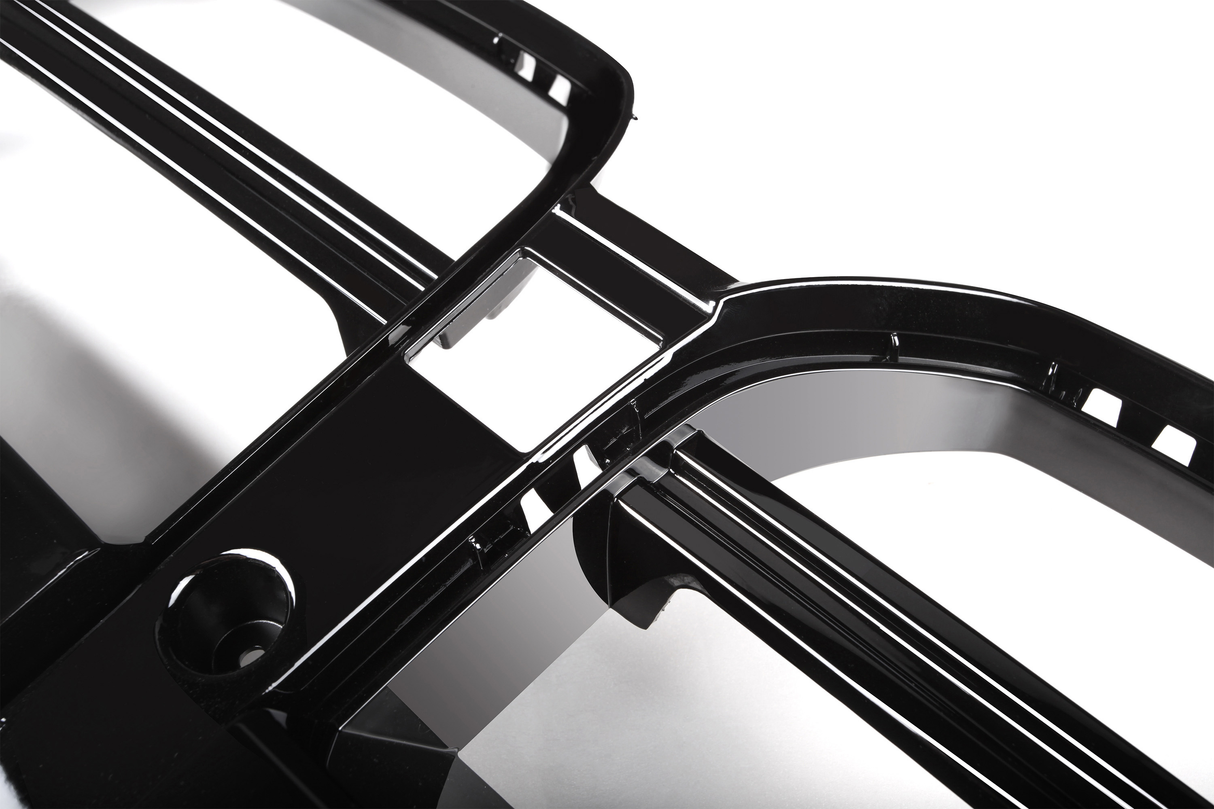 Shiny black plastic frame with curved edges intersecting at right angles, placed on a reflective white surface.