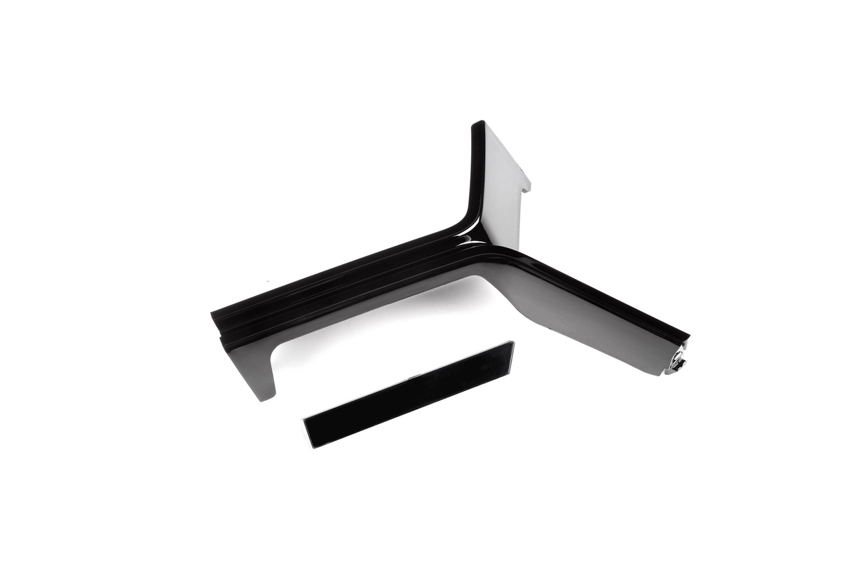 A black, L-shaped bracket with a sleek finish lies on a white surface. Nearby, a detached rectangular piece is positioned parallel to the bracket.