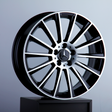 A glossy, black and chrome alloy wheel rests on a pedestal, featuring a three-pointed star emblem at its center, set against a neutral gray background.