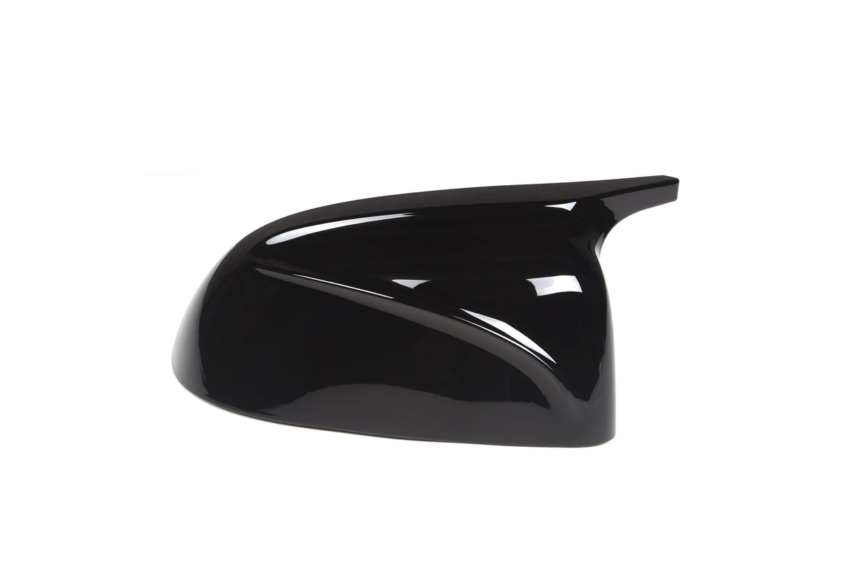 A glossy black car side mirror cover sits against a white background, showcasing its sleek, aerodynamic design with smooth curves and a sharp edge extending backward.