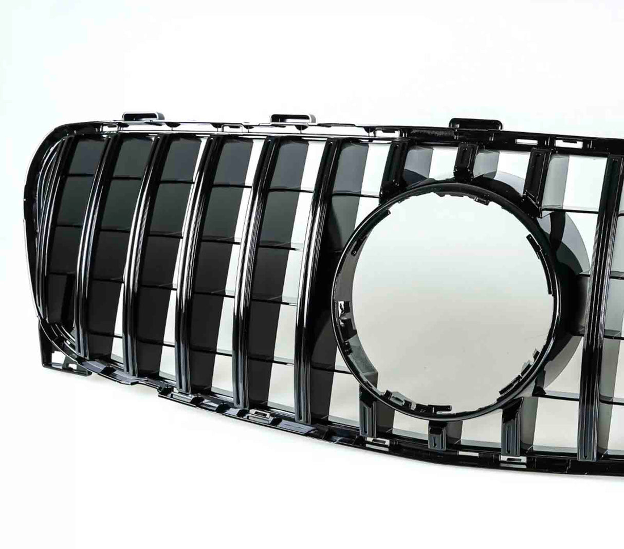 A black car grille features vertical slats and a central circular frame. It is positioned against a plain white background, highlighting its glossy surface and geometric design.