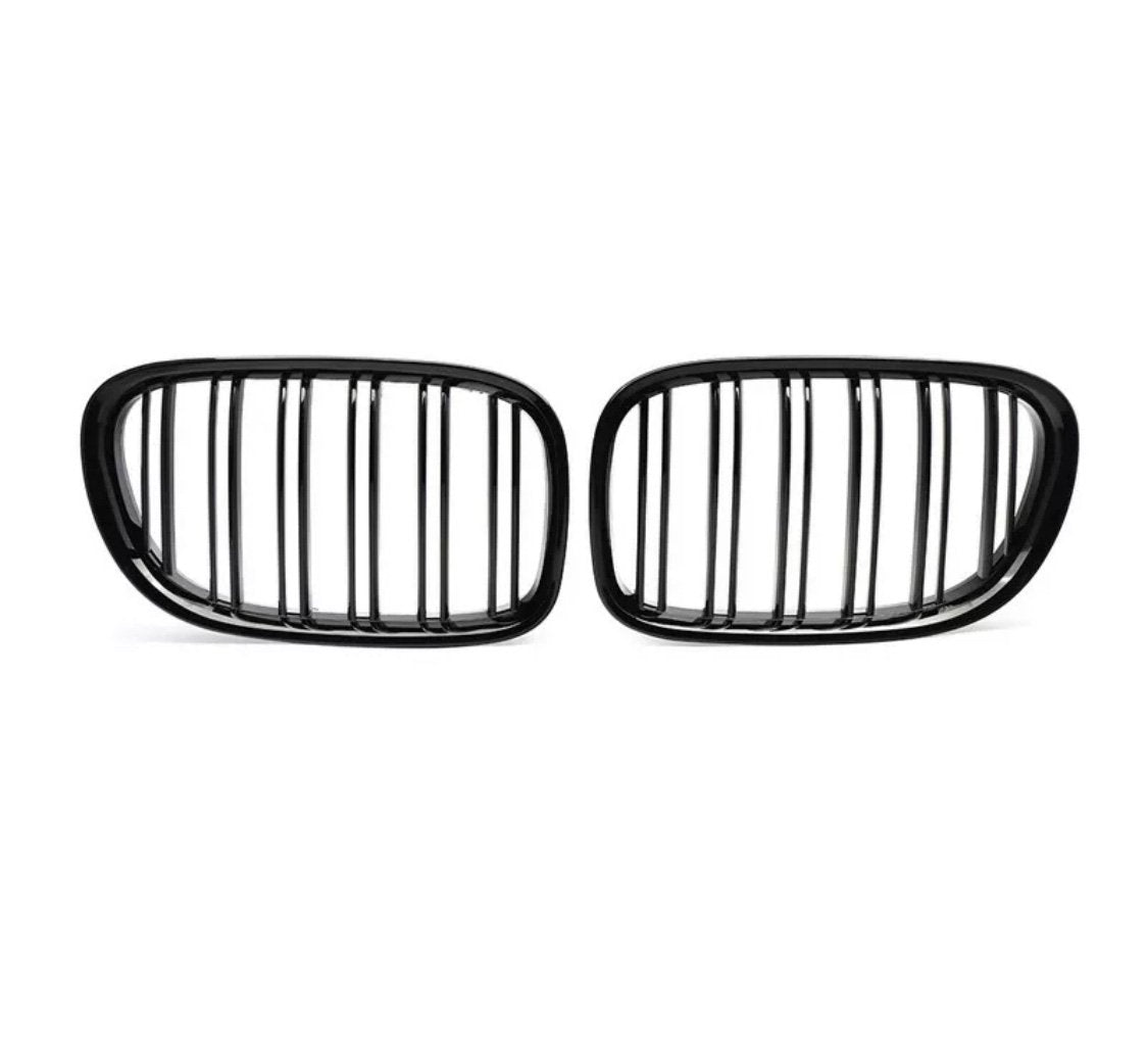 Two black, oval car grilles with vertical slats stand side by side against a white background, highlighting their sleek, symmetrical design.