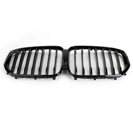 A black, dual kidney-shaped car grille features vertical slats, designed for a vehicle's front end. It rests against a plain white background, emphasizing its sleek design.