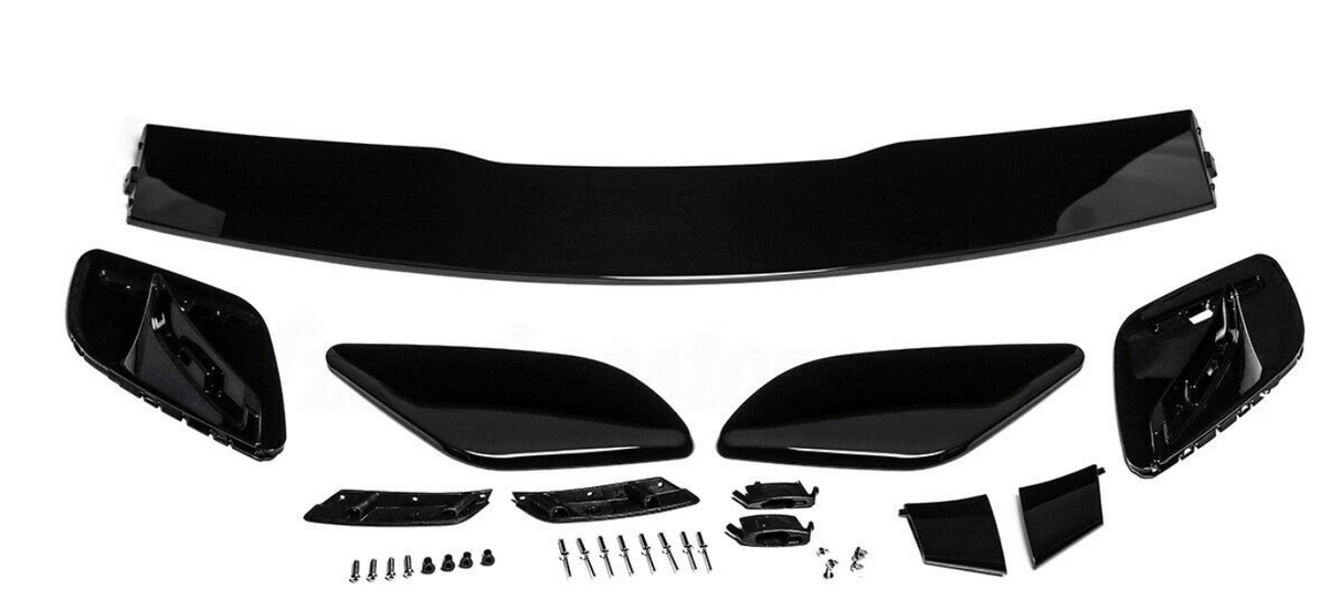 Car spoiler kit with black aerodynamic components laid out on a white surface. Includes a large wing, side pieces, and multiple small parts and screws for assembly.