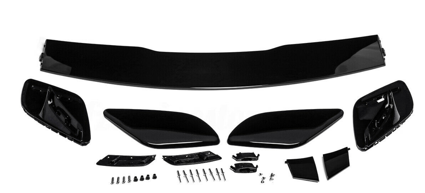 Car spoiler kit with black aerodynamic components laid out on a white surface. Includes a large wing, side pieces, and multiple small parts and screws for assembly.
