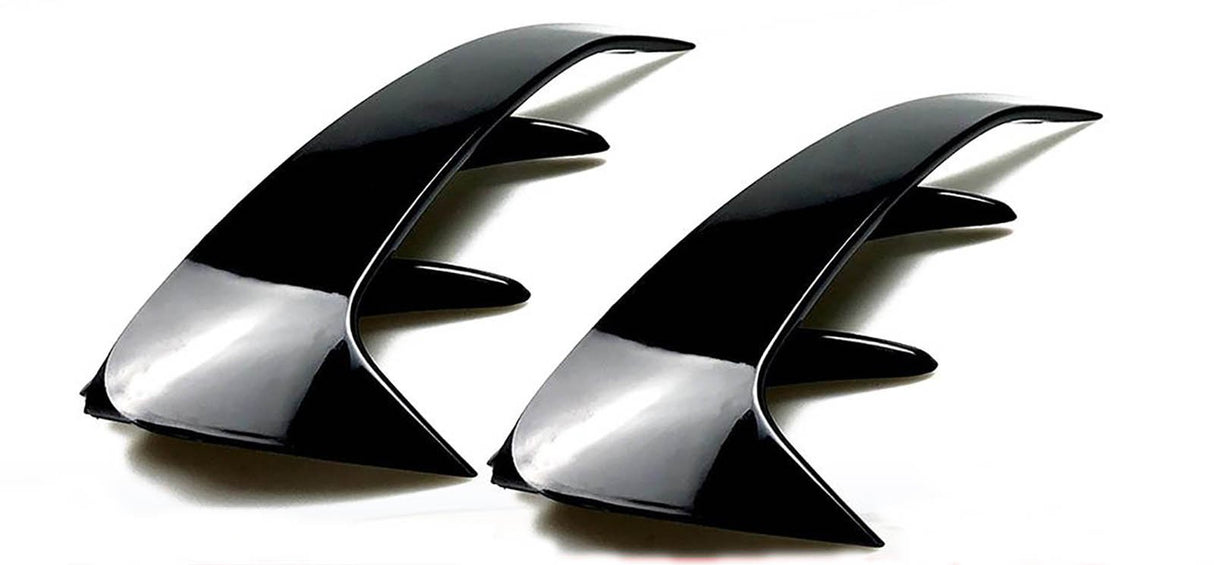 Two sleek, black, curved automotive fins with angular protrusions are positioned side by side on a plain white background, emphasizing their glossy finish and aerodynamic design.