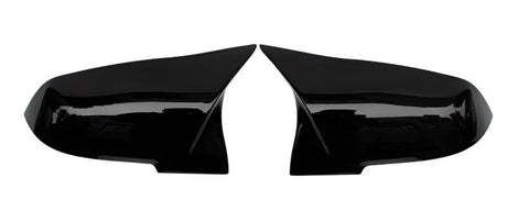 Two glossy black side mirror covers lie adjacent, separated, facing each other against a plain white background.