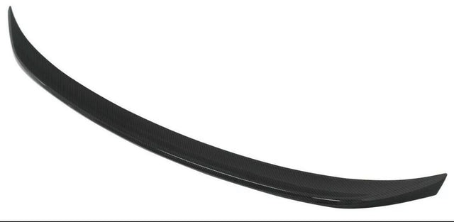A black, curved car spoiler made of carbon fiber material is displayed against a plain white background.