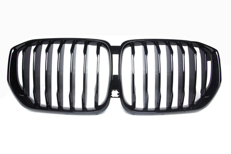 A shiny black car grille with vertical slats, forming two adjacent kidney-shaped sections, set against a plain white background.