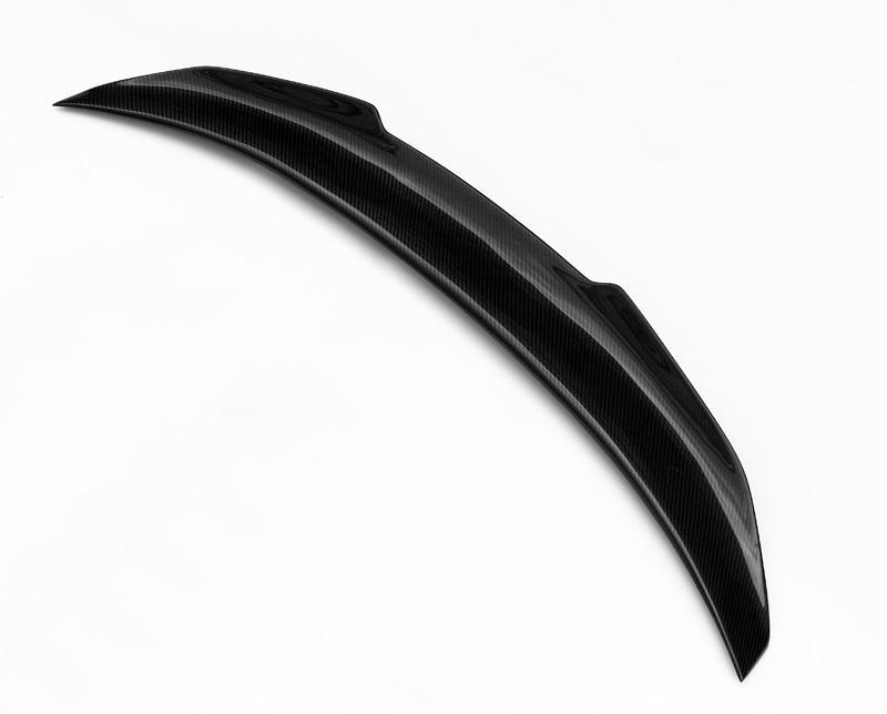 A curved black car spoiler rests on a plain white background, showcasing its sleek carbon fiber texture and aerodynamic design.