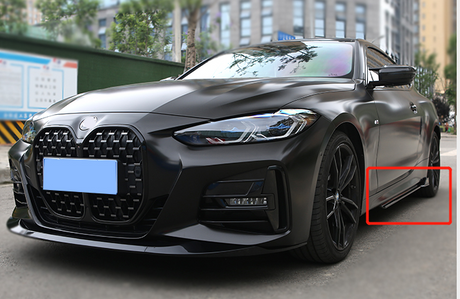 A sleek, black car is parked on a city street. Its shiny exterior and modern design, featuring an intricate front grille and sharp headlights, stand out against the urban setting.