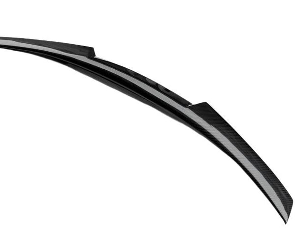 A sleek, curved black spoiler with a carbon fiber texture rests in isolation against a plain white background.