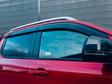 A red vehicle is parked with closed windows reflecting a cloudy sky. The background features a corrugated metal wall. A side mirror protrudes, and no text is visible.