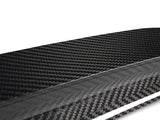 A sleek carbon fiber sheet displaying a distinctive woven pattern; it sits on a plain white background, emphasizing its glossy texture and modern aesthetic.