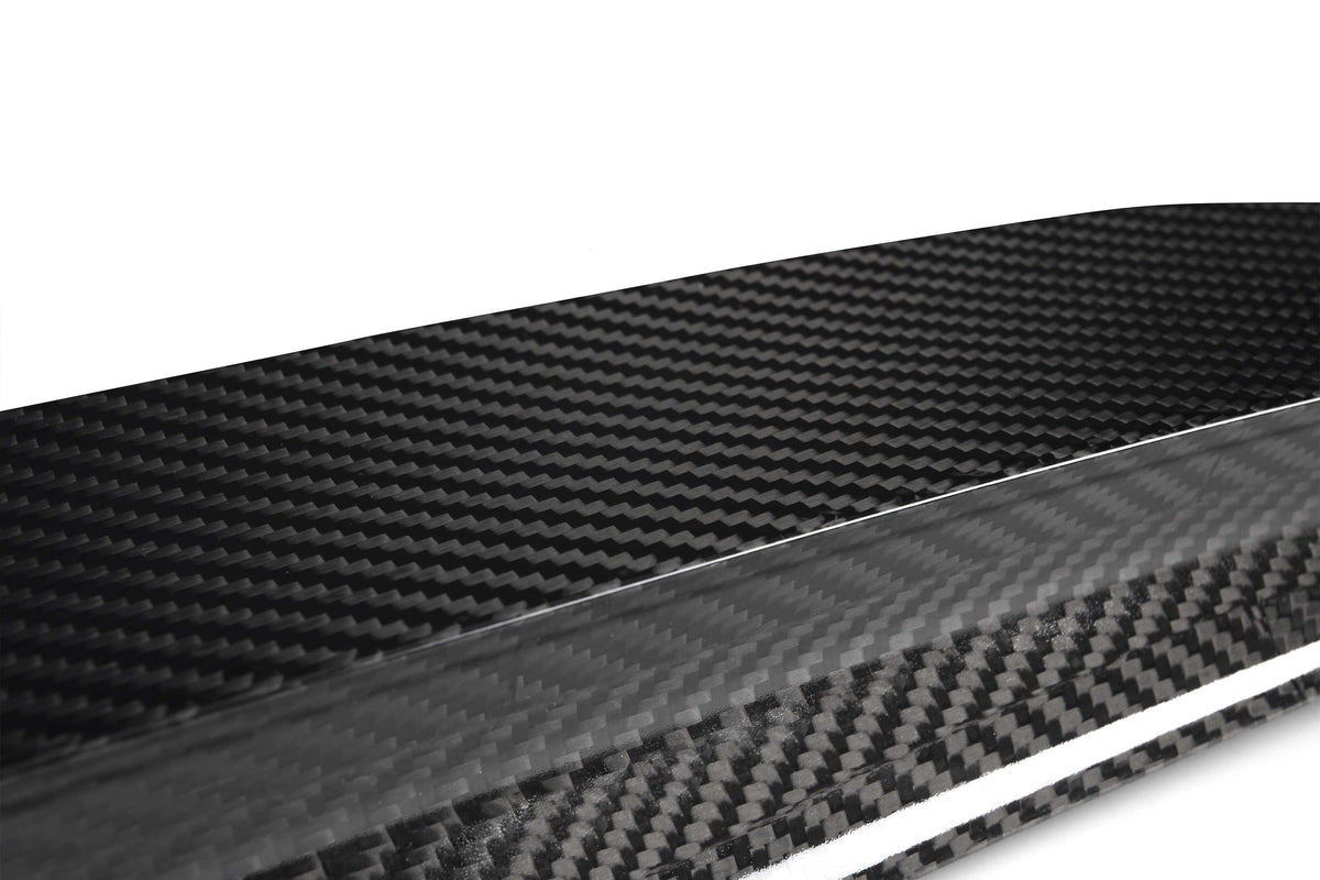 A sleek carbon fiber sheet displaying a distinctive woven pattern; it sits on a plain white background, emphasizing its glossy texture and modern aesthetic.