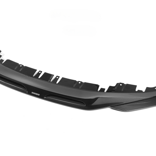 A black carbon fiber car front splitter with several attachment points lies against a plain white background. Text on the splitter reads "SODOCOO."