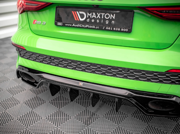 A green car's rear bumper displays Maxton Design branding above the "Rs 3" badge, with a textured black design and diffuser, parked on a patterned surface. Logos and text are visible.