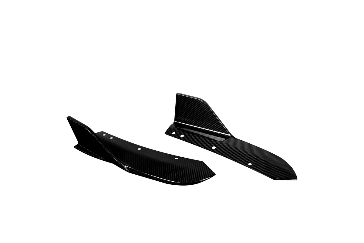 Two black carbon fiber car splitters with angular designs, featuring several circular holes, are placed against a plain white background, showcasing their sleek aerodynamic form.