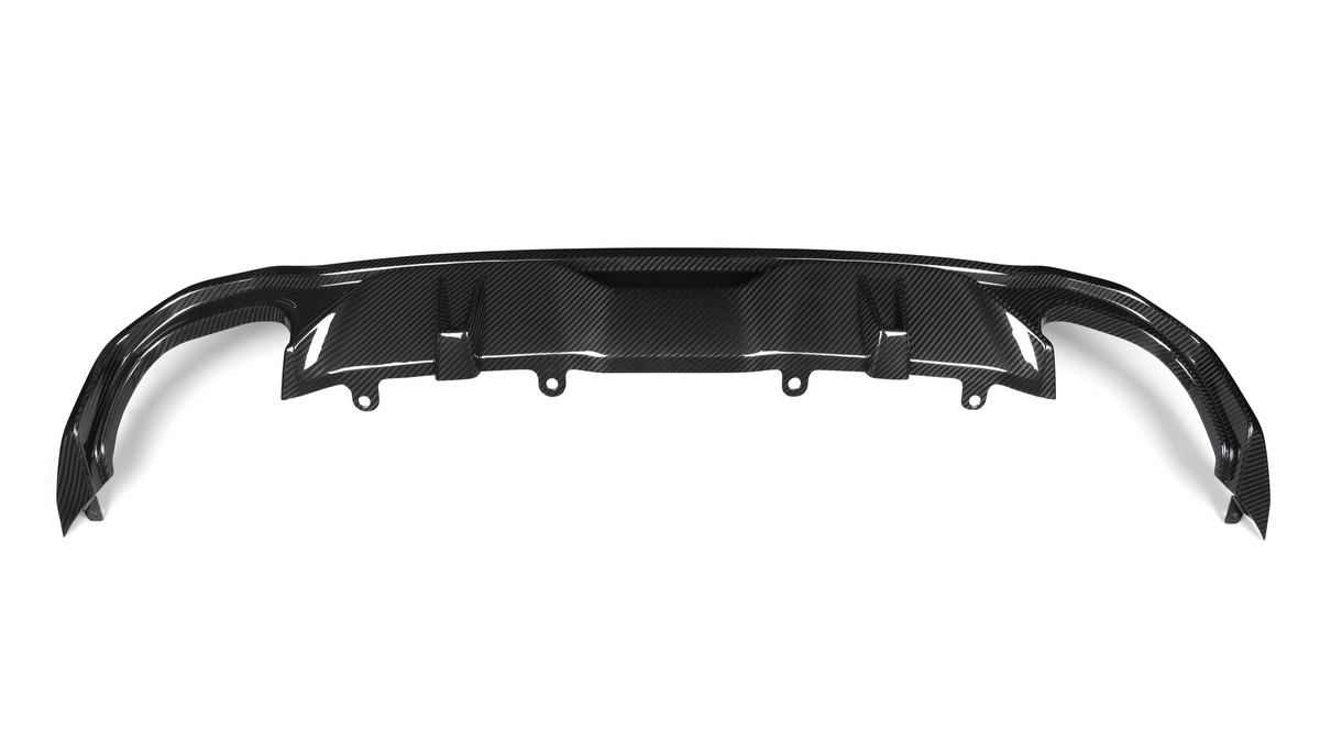 A carbon fiber rear diffuser with multiple fins is positioned horizontally, intended for aerodynamic improvement in a vehicle setting. The background is plain and white.