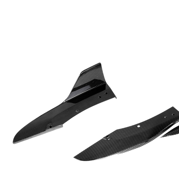 Two black carbon fiber car components are shown, featuring streamlined curves and holes for attachment, set against a plain white background.