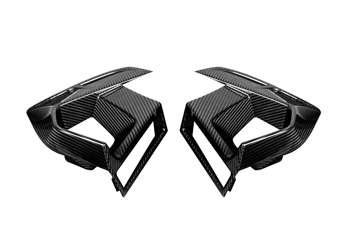 Two black carbon fiber car air vents, styled with sleek lines and sharp angles, face each other on a plain white background.
